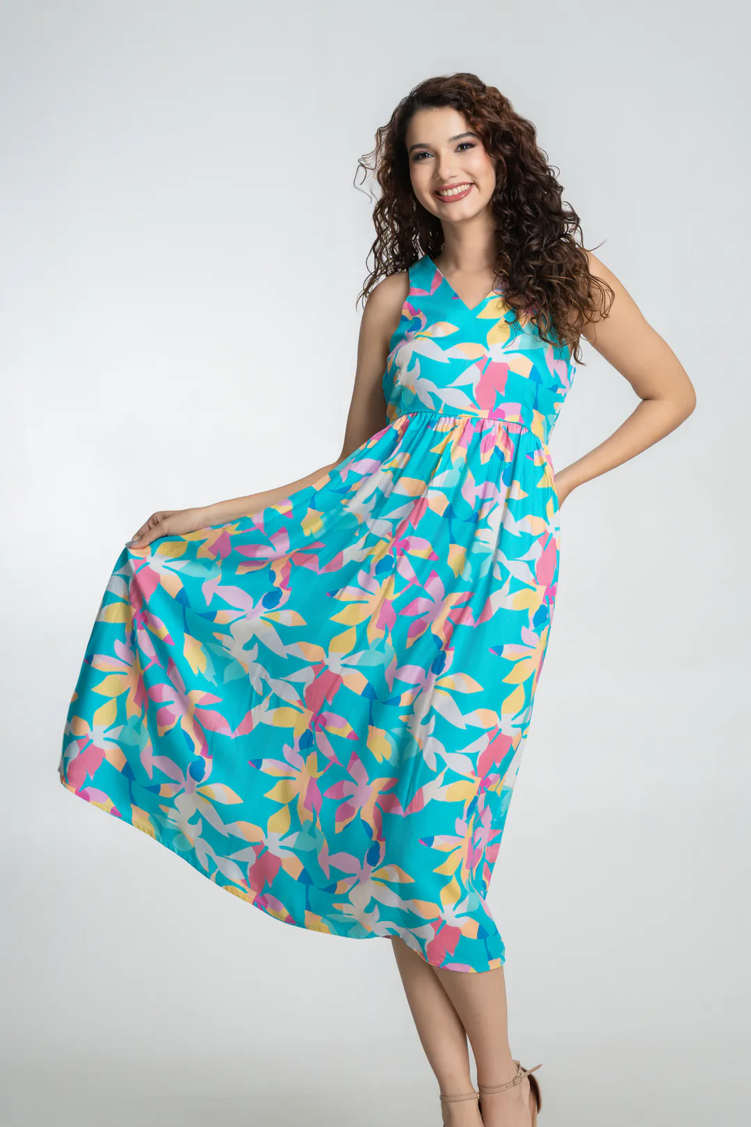 Model holding out the skirt of a turquoise midi dress with a pastel floral print